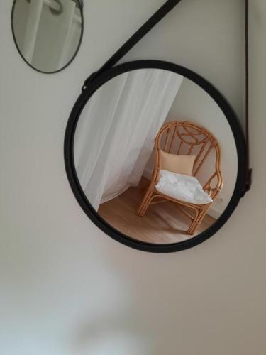 a mirror hanging on a wall with a chair at L'inattendu in Saint-Alban
