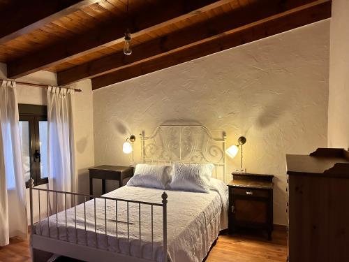 1 dormitorio con cama y pared blanca en La Cija Olmedo, en Olmedo