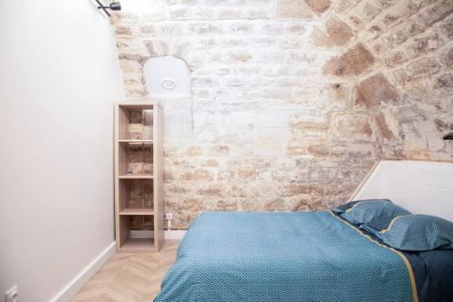 une chambre avec un mur de briques et un lit dans l'établissement Apartment lyonnais center of paris, à Paris