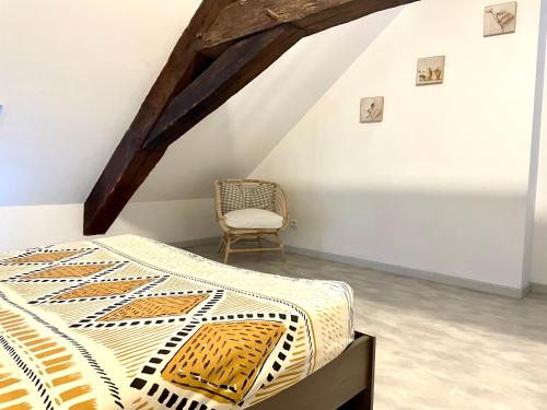 een slaapkamer met een bed en een stoel bij Appartement La Tour in Vesoul