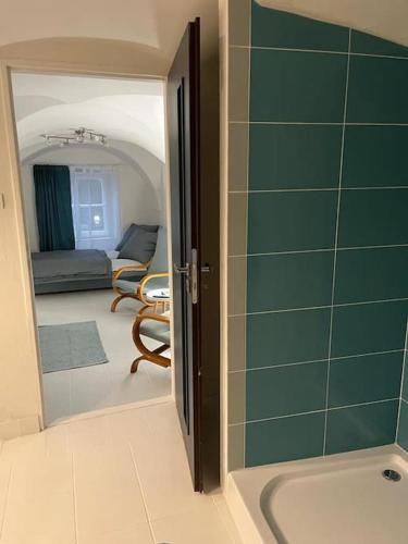a bathroom with a sink and a living room at city center Santorín in Banská Bystrica