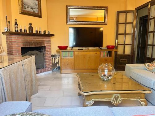 a living room with a tv and a fireplace at Casa Plaza Sierra Grazalema in Grazalema