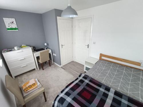 a bedroom with a bed and a desk and a chair at Comfortable room in Yeovil near A303 exit & Football Club in Montacute