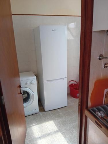 a small kitchen with a washing machine and a refrigerator at T3 2 Andar Ref 007 in Tavira