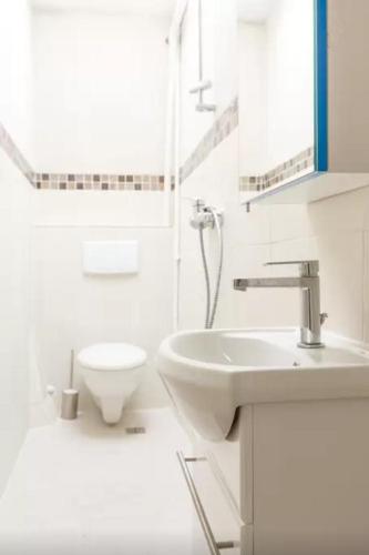 une salle de bain blanche avec un lavabo et des toilettes dans l'établissement Private room center Paris, à Paris