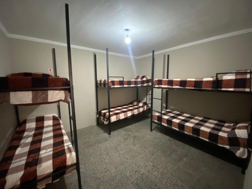 three bunk beds in a room with a light on at Urban Jungle Hostel in San Miguel de Tucumán