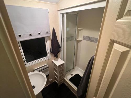 a small bathroom with a sink and a shower at Chestnut grove, Thorpe park in Humberston