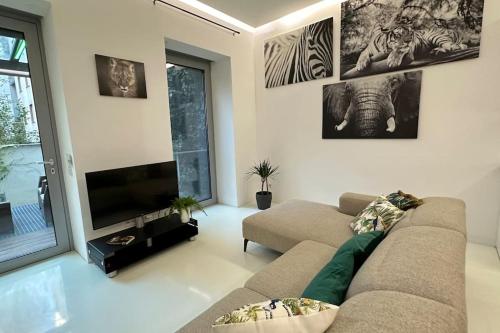 een woonkamer met een bank en een flatscreen-tv bij African Paradise with Jacuzzi & Sauna in Wenen
