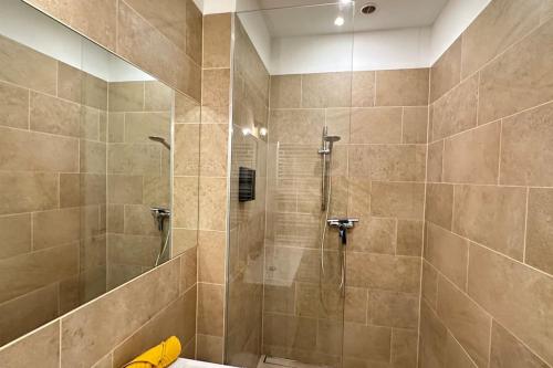 a bathroom with a shower with a glass door at African Paradise with Jacuzzi & Sauna in Vienna