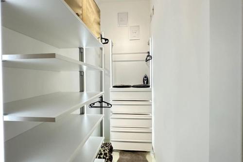 a white walk in closet with white shelves at African Paradise with Jacuzzi & Sauna in Vienna