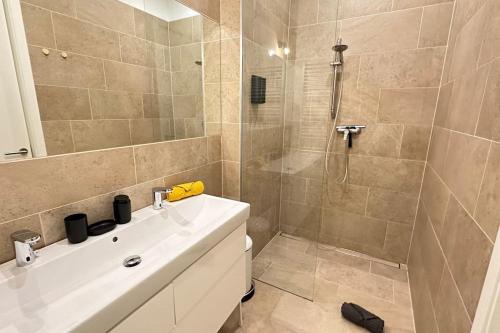 a bathroom with a white sink and a shower at African Paradise with Jacuzzi & Sauna in Vienna