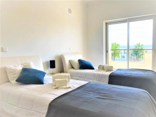 ラゴスにあるLagos Stunning Apartmentsの大きな窓付きの客室で、ベッド2台が備わります。