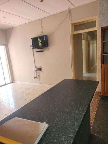 una camera con un bancone nero e una TV a parete di HUNTERS NEST GUEST HOUSE MAFIKENG a Mahikeng