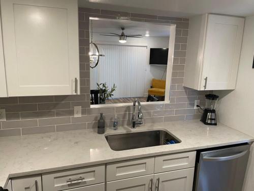 a kitchen counter with a sink and a mirror at Casa Wooten - Pet Friendly in Austin