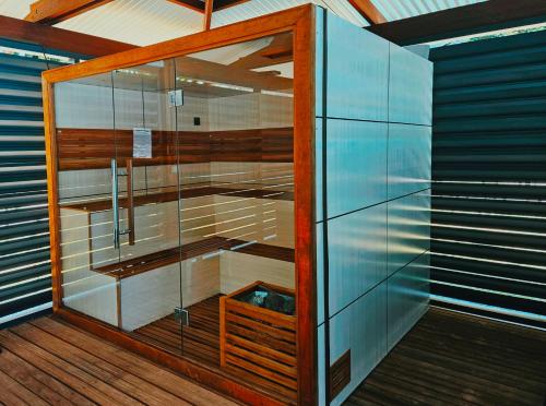 una sauna con una puerta de cristal en una terraza de madera en SAS CLP - La Marina, en Kourou