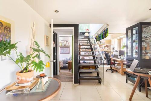 an office with a desk and a spiral staircase at Pequeña habitacion FRIDA - design CDMX - áreas comunes compartidas in Mexico City