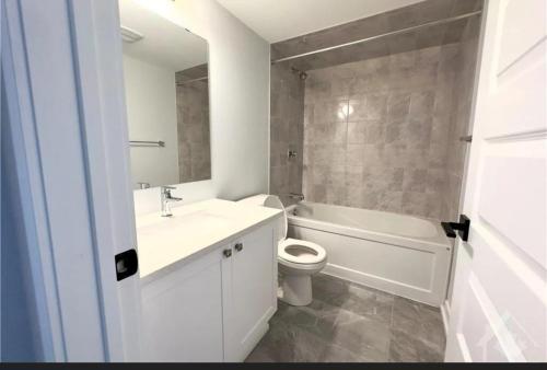 a bathroom with a sink and a toilet and a tub at Townhouse in Ottawa