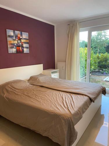 Schlafzimmer mit einem großen Bett und einem Fenster in der Unterkunft Ferienwohnung Köln in Köln