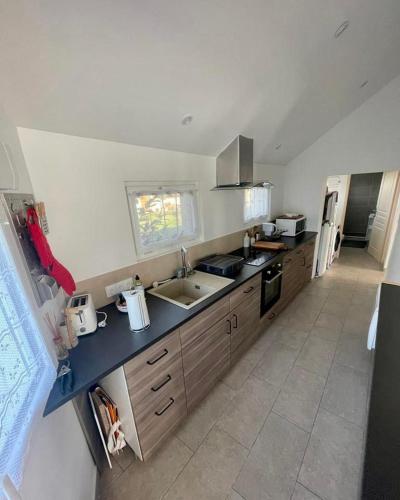 une cuisine avec un évier et un plan de travail dans l'établissement Maison 5 p, face Mont St Michel, à Huisnes-sur-Mer