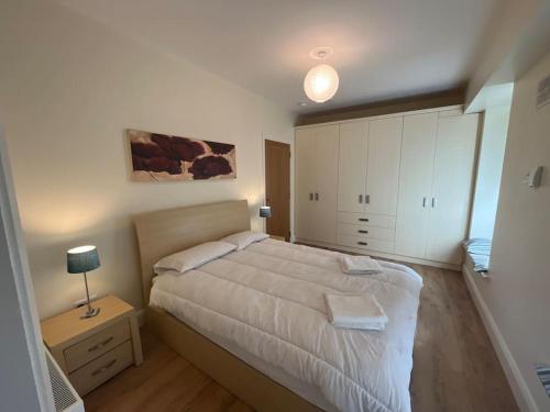 sypialnia z łóżkiem i nocną szafką z lampką w obiekcie Coastal Dublin, 4 adult bed spaces+child max w Dublinie