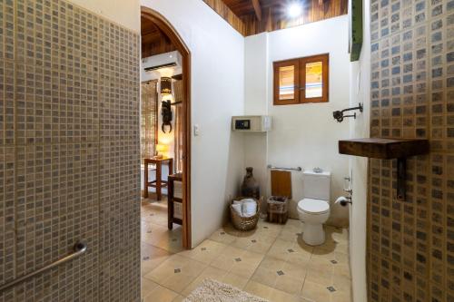 a bathroom with a toilet and a walk in shower at Blue Surf Sanctuary in Santa Teresa Beach