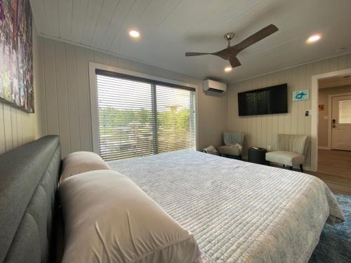 a bedroom with a bed and a ceiling fan at Canary Lake Cottage w/Hot Tub at Sam's Pizza in Hot Springs