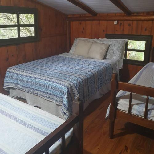 een slaapkamer met een bed en een stoel bij Sitio do Sol quarto wc compartilhado in Guabiruba