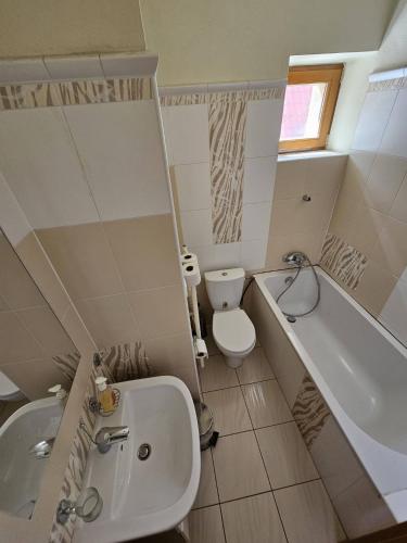 a bathroom with a tub and a toilet and a sink at Penzion pod Krivanom in Liptovský Hrádok