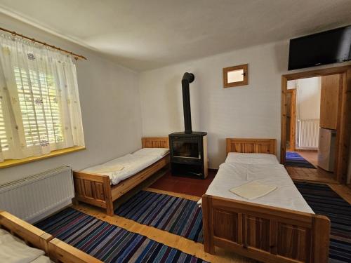 a room with two beds and a wood stove at Penzion pod Krivanom in Liptovský Hrádok