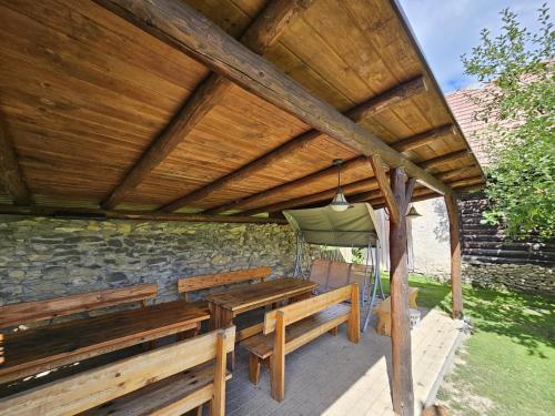 a patio with benches and a table and a chair at Penzion pod Krivanom in Liptovský Hrádok