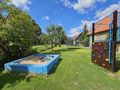 a play area with a sandbox and a rock wall at Penzion pod Krivanom in Liptovský Hrádok