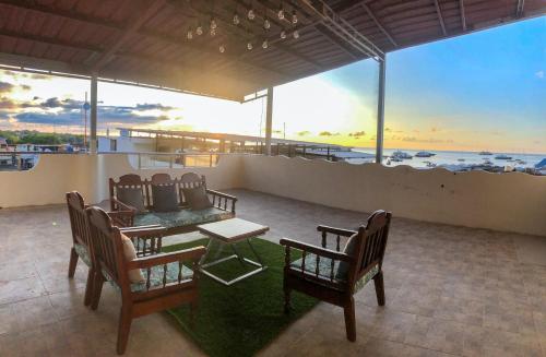 a patio with chairs and a table with a view of the ocean at Kicker House in Puerto Baquerizo Moreno