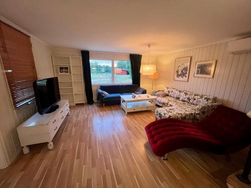 - un salon avec un canapé et une télévision dans l'établissement Idylliskt hus med sjöutsikt., à Östhammar