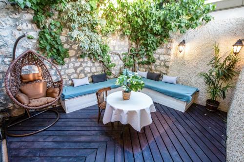 a patio with a wicker couch and a table at Villa Maim Haim Prime Location Old City Tzfat in Safed