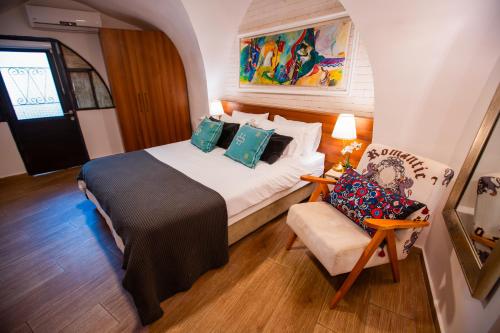 a bedroom with a bed and a chair in a room at Villa Maim Haim Prime Location Old City Tzfat in Safed