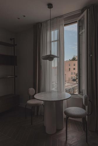 une table et des chaises dans une pièce avec une fenêtre dans l'établissement Modern Studio next to Monaco, à Beausoleil