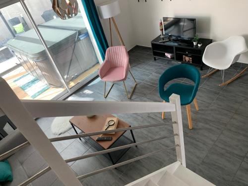 een woonkamer met 2 stoelen en een televisie bij Découvrez l'Inatten'Bulle ! in Bétheny