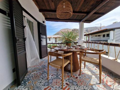 d'une terrasse avec une table et des chaises sur un balcon. dans l'établissement Ossidiana Rossa Elegant Suite Vulcano, à Vulcano