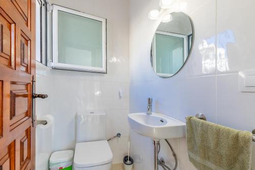a bathroom with a sink and a toilet and a mirror at Cap d´Or house in Moraira