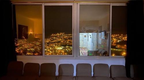 a view of a city skyline from a window at Petra Everest Hostel in ‘Ayn Amūn