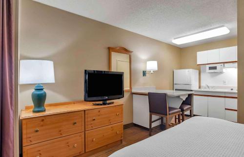 a hotel room with a bed and a television on a dresser at Extended Stay America Suites - San Diego - Sorrento Mesa in Sorrento