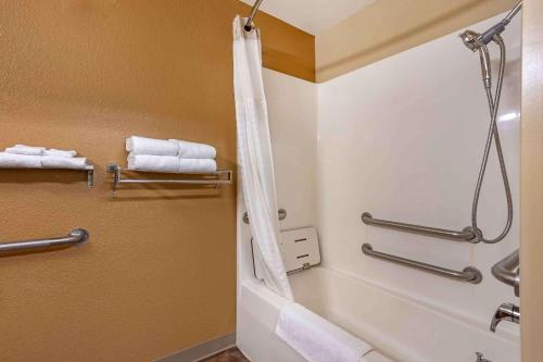 een badkamer met een bad, een douche en handdoeken bij Extended Stay America Suites - Columbia - Stadium Blvd in Columbia