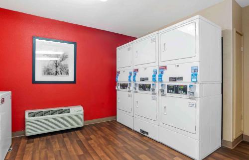 a room with a bunch of machines against a red wall at Extended Stay America Suites - Los Angeles - Torrance Harborgate Way in Carson