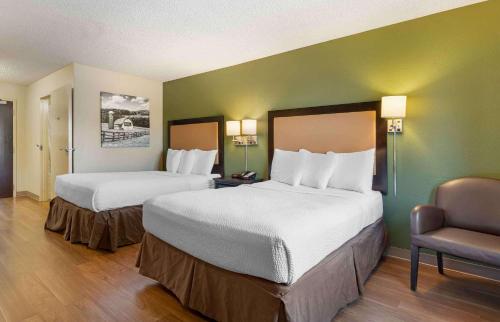 una habitación de hotel con 2 camas y una silla en Extended Stay America Suites - Richmond - Hilltop Mall, en Richmond