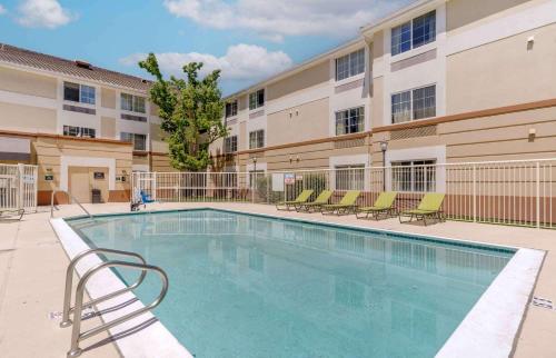 una piscina con sillas y un edificio en Extended Stay America Suites - Pleasanton - Chabot Dr, en Pleasanton