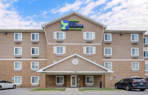 a large building with a sign on top of it at Extended Stay America Select Suites - Louisville - Airport in Louisville
