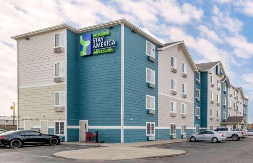 a large blue building with cars parked in a parking lot at Extended Stay America Select Suites - Lubbock - West in Lubbock