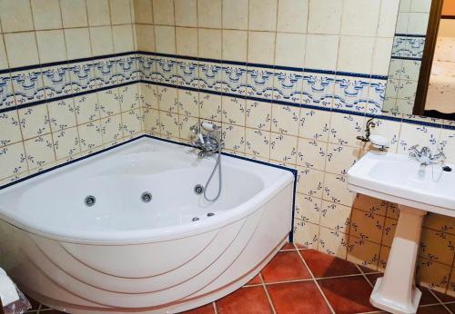 un bagno con vasca e lavandino. di Casa Rural Piedras de Benquerencia a Benquerencia