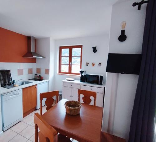 uma cozinha com uma mesa de madeira e uma sala de jantar em Studio vue montagnes, RDC, parking em Cauterets
