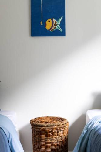 a wicker basket sitting next to a wall with a picture of a fish at Tyrone Sands Rye in Rye